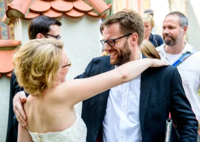Brautpaar lacht herzlich bei Hochzeitsfeier in Schwabing, aufgenommen von einem Hochzeitsfotografen aus München.