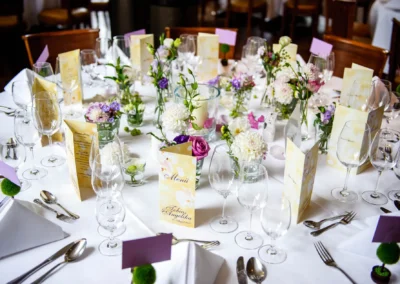Elegant gedeckter Hochzeitstisch mit Blumen und Menukarten, aufgenommen in Seehaus. Hochzeitsfotografie in Muenchen.
