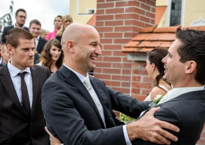 Männer in Anzug lachen während einer Hochzeitsreportage in Arget. Hochzeitsfotografie im Landkreis München.