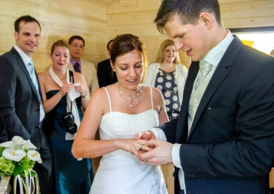 Brautpaar tauscht Ringe vor Gästen bei Hochzeit nahe Eibsee. Hochzeitsfotograf hält diesen besonderen Moment fest.