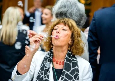 Frau pustet Seifenblasen bei Hochzeitsfeier nahe Tegernsee, festgehalten von Hochzeitsfotograf.