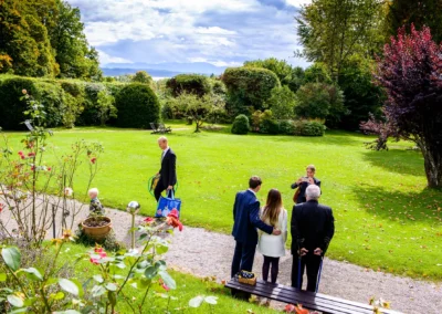 Hochzeitsfotografie in Feldafing: Gäste im Park, jemand macht ein Foto. Perfekte Kulisse für eine Hochzeitsreportage.