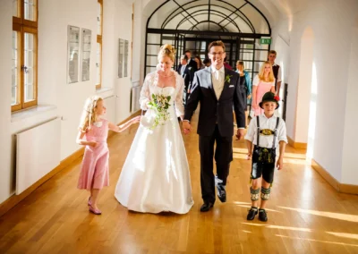 Brautpaar mit Kindern bei Hochzeitsreportage im Kloster Seeon, Bayern. Fröhliche Hochzeitsmomente festgehalten.