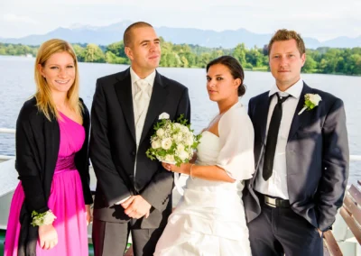 Brautpaar mit Freunden bei der Hochzeit auf einem Boot auf dem Staffelsee. Hochzeitsfotografie im Freien.