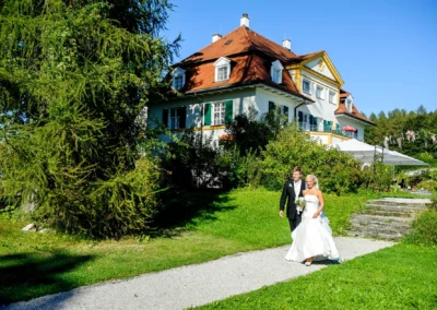 Brautpaar spaziert im Garten von Schlossgut Oberambach an ihrem Hochzeitstag. Hochzeitsfotografie südlich München.
