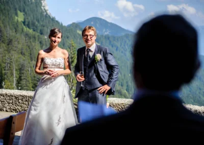 Brautpaar bei Hochzeitsreportage nahe Kampenwand, Hochzeitsfotografie in den Bergen mit Blick auf Wald und Gebirge.