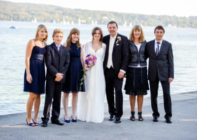 Brautpaar mit Familie am Starnberger See, aufgenommen von einem Hochzeitsfotografen.