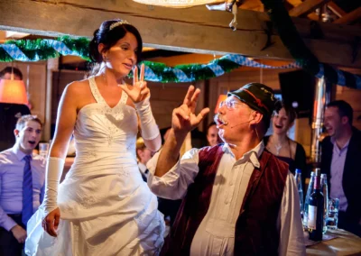 Braut im weissen Kleid mit Gast bei Hochzeitsfeier in Paulaner Seegarten, heitere Atmosphaere. Hochzeitsfotografie.