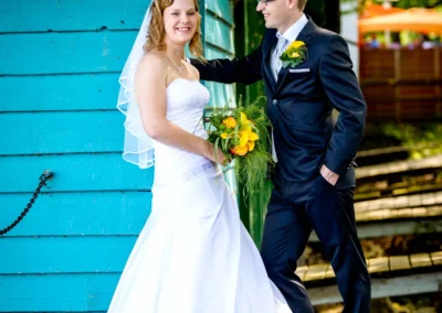 Hochzeitsfoto von Brautpaar vor blauer Wand am Starnberger See, aufgenommen von einem Hochzeitsfotografen.
