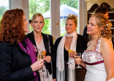 Frauen bei einer Hochzeitsfeier am Walchensee mit Getraenken. Hochzeitsfotografie von emotionalen Momenten.
