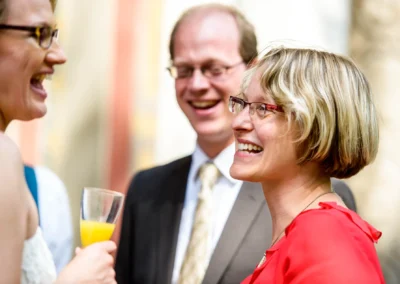 Lachende Gaeste auf einer Hochzeit in Muenchen Schwabing, festgehalten von einem Hochzeitsfotografen.