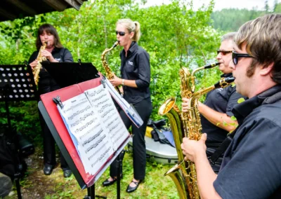Musiker spielen Saxophon auf einer Hochzeit am Eibsee, Hochzeitsfotograf fängt die Stimmung im Freien ein.