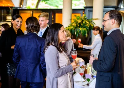 Gaste unterhalten sich bei Hochzeitsempfang im Seehaus, Schwabing mit Cocktails und eleganter Kleidung. Hochzeitsreportage.