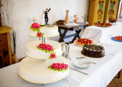 Hochzeitstorte mit Figuren und rosa Rosen bei Hochzeitsfeier in Landgasthof Stahuber Thal, nahe Rosenheim.