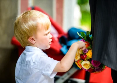 Kind mit Blumenstrauss bei Hochzeitsreportage in Muenchen Schwabing. Natuerlicher Moment aus der Hochzeitsfotografie.