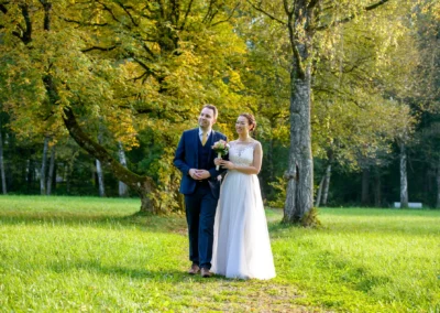Brautpaar beim Spaziergang in Fischbachau, umgeben von herbstlichen Baumen, Hochzeitsfotografie im Leitzachtal.