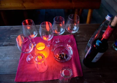 Weinglaeser und Kerze auf Tisch bei Hochzeit im Paulaner Seegarten. Hochzeitsszene mit Glas und Rotwein in Abendstimmung.