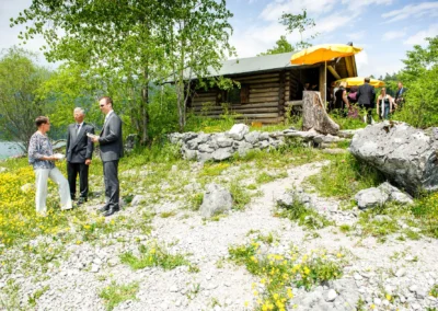 Hochzeitsreportage am Eibsee: Gruppe in Anzug bei einer Huette in natuerlicher Umgebung. Hochzeit nahe Garmisch.