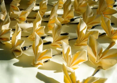 Faltservietten und Besteck bei einer Hochzeit am Starnberger See ins Sonnenlicht getaucht. Hochzeitsfotografie.