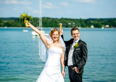Brautpaar am Starnberger See, Brautstrauss und Eis, strahlende Sonne bei der Hochzeitsfotografie.