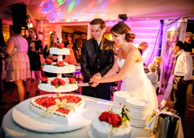 Brautpaar schneidet Hochzeitstorte an. Feier bei Hochzeitsfotografie im kleinen Seehaus, suedlich Muenchen.