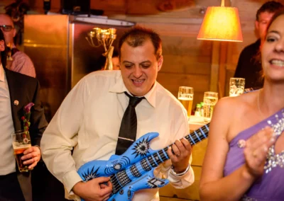 Mann spielt Luftgitarre bei einer Hochzeit, Partyatmosphäre im Paulaner Seegarten, fröhliche Hochzeitsfotografie.