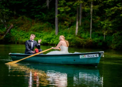 Brautpaar lacht in Ruderboot auf See nahe Hotel am Badersee, Teil einer Hochzeitsreportage in malerischer Natur.