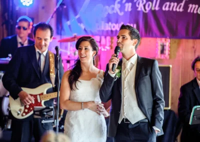 Brautpaar spricht bei Hochzeitsfeier im Gasthof Schmuck, begleitet von Band, Hochzeitsfotografie in Sauerlach.