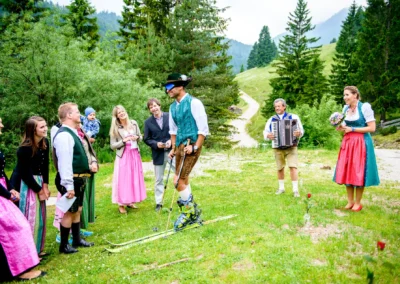Gäste in Tracht bei Hochzeit im Freien im Sillberghaus, Bayrischzell. Festliche Stimmung und Musikbegleitung.