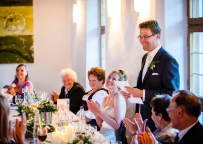 Brautpaar und Gaeste applaudieren bei Hochzeit im Kloster Seeon. Hochzeitsfotografie im Chiemgau, festliche Stimmung.