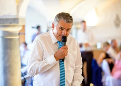 Mann haelt eine Rede bei einer Hochzeit im Landgasthof Stahuber Thal. Hochzeitsfoto zeigt feierliche Stimmung.