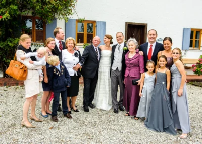 Gruppe von Hochzeitsgaesten posiert fuer Foto bei Hochzeit auf Gut Thurnsberg, Oberbayern. Hochzeitsreportage.