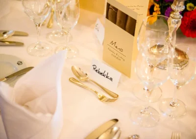 Elegante Tischdekoration mit Menu und Namensschild bei Hochzeit am Starnberger See. Hochzeitsfoto von stilvollem Anlass.