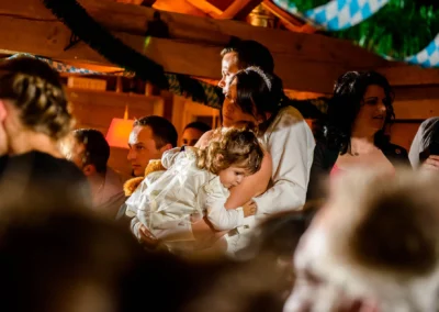 Hochzeitsfoto im Paulaner Seegarten: Feier mit Kind auf dem Arm in entspannter Atmosphaere. Hochzeitsreportage.