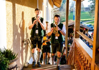 Musikband in traditioneller Tracht auf einer Hochzeit in Kreis Rosenheim, begleitet von Instrumenten. Hochzeitsfotografie.