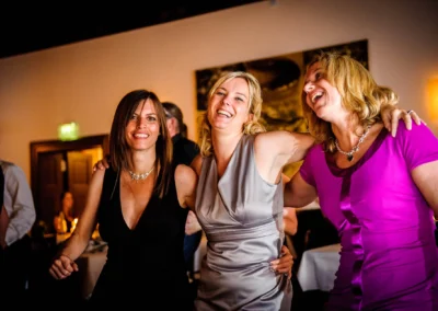 Drei Frauen lachen bei einer Hochzeit im Kloster Seeon, fotografiert von einem Hochzeitsfotografen aus Oberbayern.