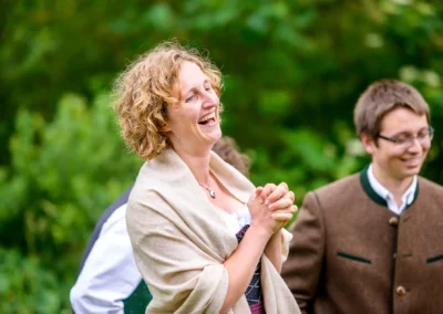 Lachende Frau und Mann in traditioneller Kleidung bei einer Hochzeit im Almbad-Sillberghaus, Hochzeitsreportage.