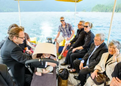 Hochzeitsgesellschaft aus Grainau in einem Boot auf dem Eibsee. Aufnahme bei einer Hochzeit am See.