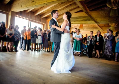 Brautpaar tanzt in Gasthof in Sauerlach, umgeben von applaudierenden Gaesten bei einer Hochzeit. Hochzeitsfotografie.