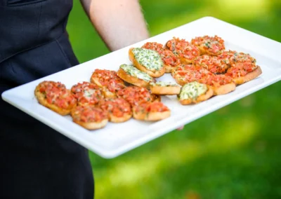 Tablett mit Bruschetta-Broten bei Hochzeit am Starnberger See, serviert von einem Kellner. Hochzeitsfotografie.