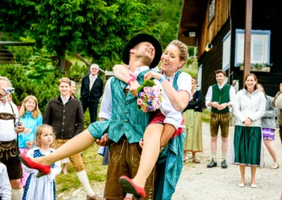 Glückliches Hochzeitspaar in traditioneller Tracht bei der Hochzeitsfeier im Sillberghaus, umgeben von Gästen.