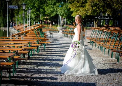 Braut in weiss im Englischen Garten, Hochzeitsportrait von Hochzeitsfotograf in Muenchen bei sonnigem Wetter.