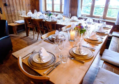 Hochzeitsfeier in Oberbayern: Stilvoll gedeckter Tisch mit Blumen und Kerzen im Almbad-Sillberghaus bei Hochzeit.
