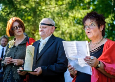 Hochzeitsreportage in Oberambach, drei Personen bei der Zeremonie, eine Frau liest von einem Blatt.