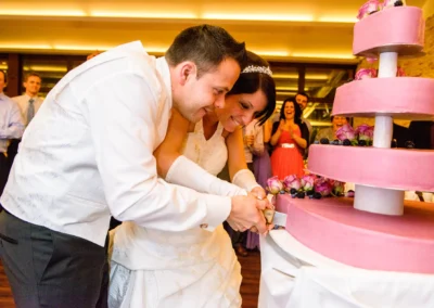 Brautpaar schneidet Hochzeitstorte bei Hochzeitsfeier im Paulaner Seegarten. Hochzeitsreportage Aufnahme.