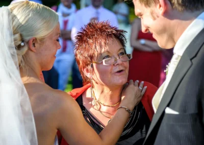 Brautpaar mit Gast im Gespraech bei Hochzeit in Oberambach. Hochzeitsfotograf dokumentiert emotionale Momente.