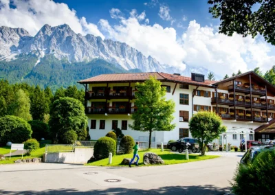 Ein Hotel am Badersee umgeben von Natur und Bergen, eine perfekte Kulisse für ein Hochzeitsfoto.