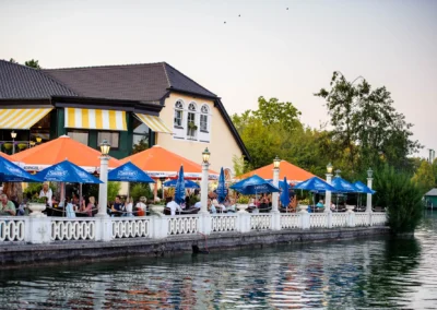 Hochzeitsreportage: Feier mit bunten Schirmen am Starnberger See, entspannte Atmosphaere bei Sonnenuntergang.