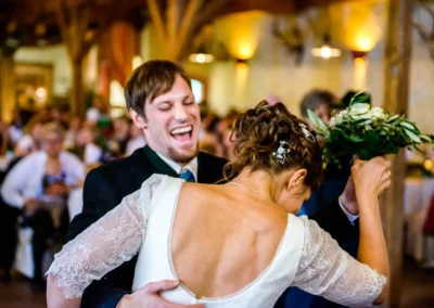 Brautpaar tanzt ausgelassen bei ihrer Hochzeitsfeier zwischen München und Rosenheim. Hochzeitsfotografie im Fokus.