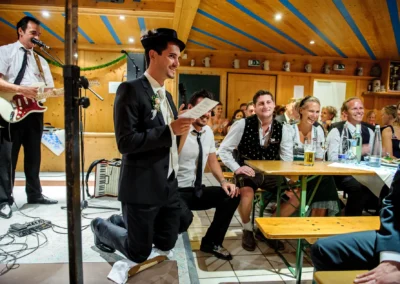 Bräutigam hält Rede bei Hochzeitsfeier in Sauerlach mit Gästen und Musik, Hochzeitsreportage im Gasthof Schmuck.